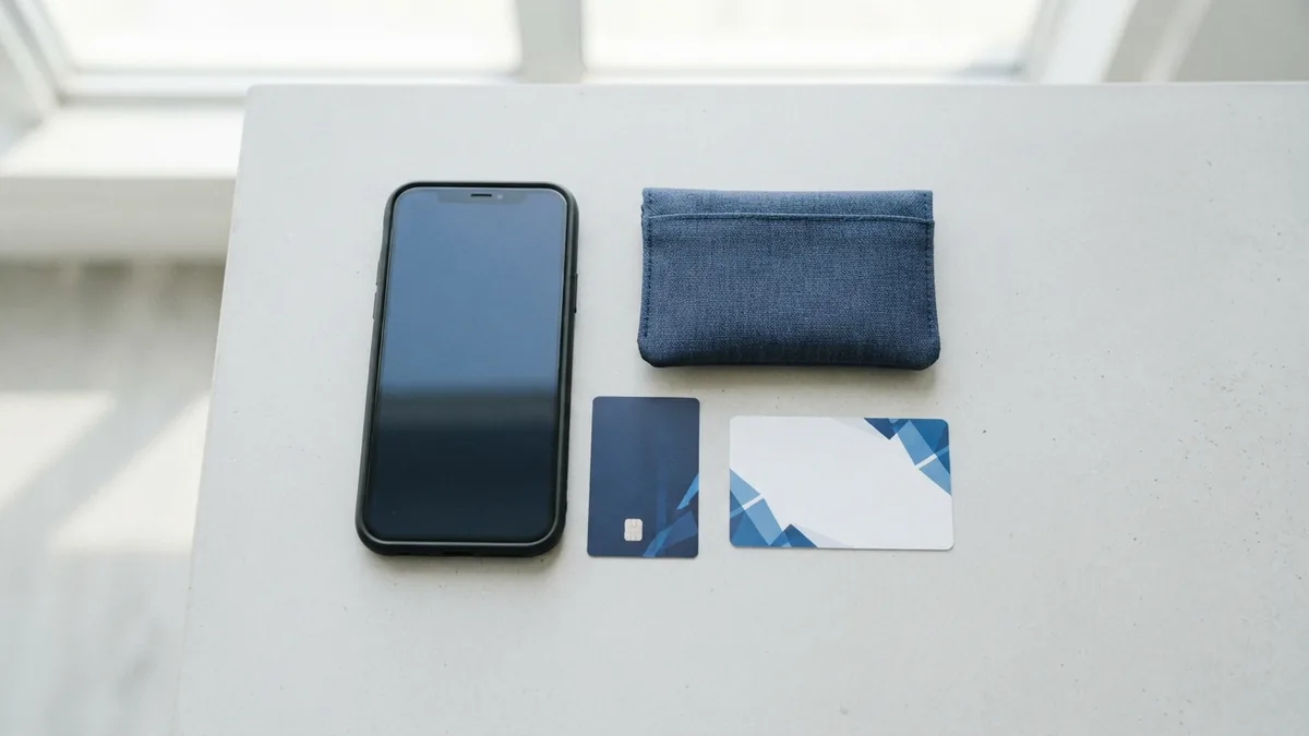 Several mobile payment tools arranged beside a smartphone and airtime card